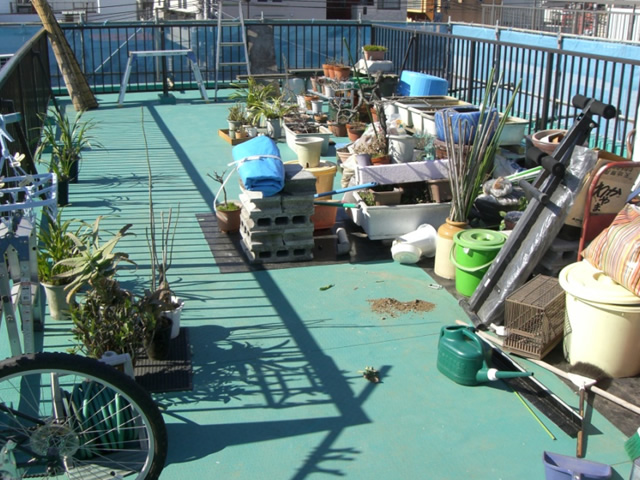 img0_3 | 東京防水職人 荷物などがたくさん置いてある屋上の状態